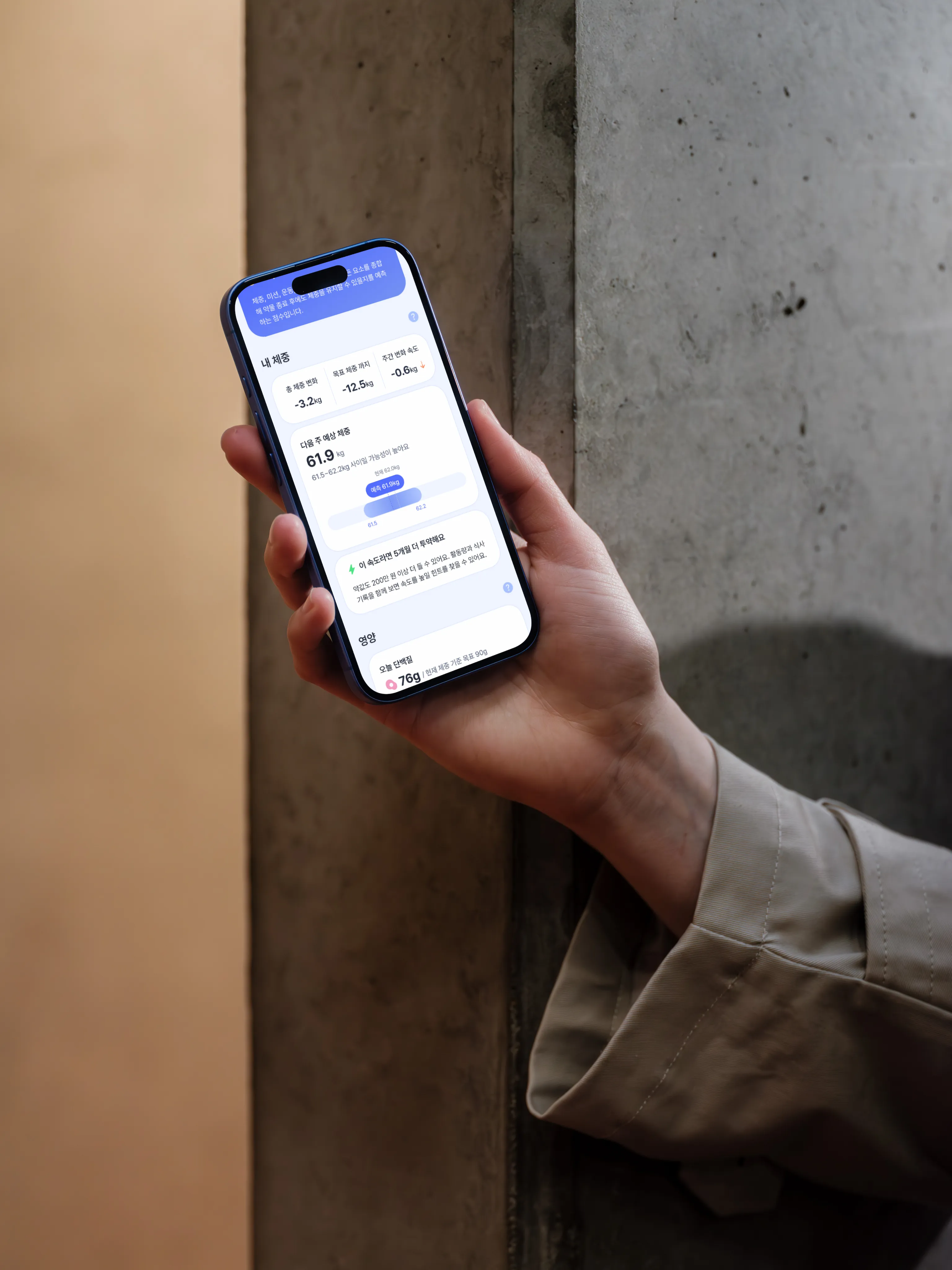 키폴로지 앱 화면이 켜진 스마트폰을 든 손